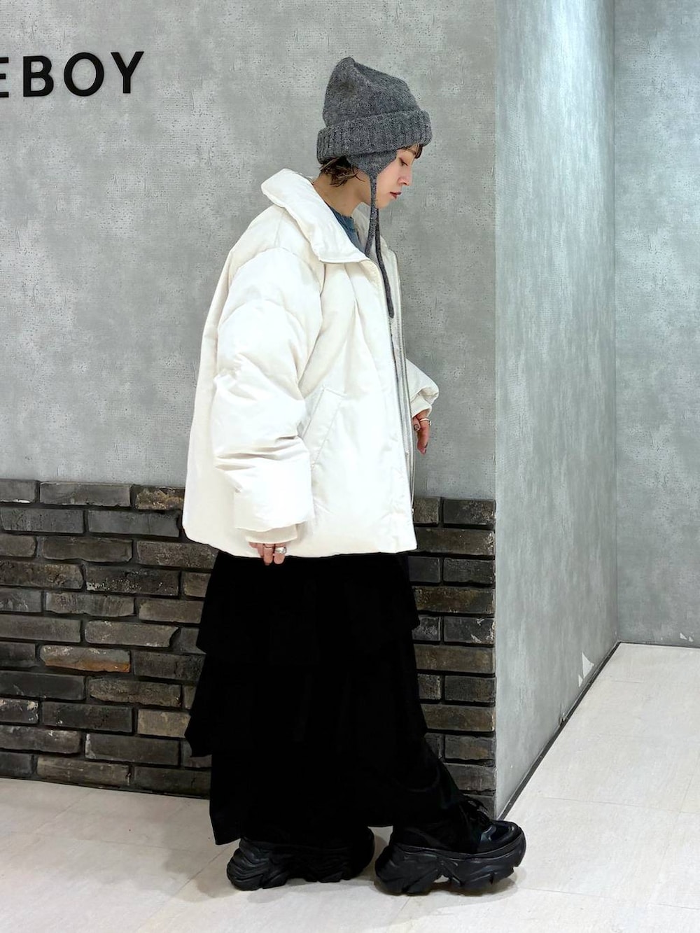 ブラック系のスニーカー、グリーン系のスウェット、ブラック系のスカートを着用したレディースの冬コーディネートの3枚目の写真