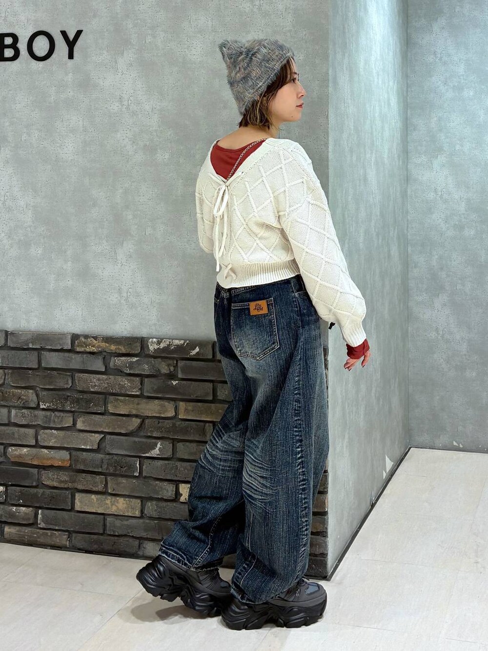 グレー系のスニーカー、ブルー系のデニムパンツ、ホワイト系のニット/セーターを着用したレディースの秋コーディネートの3枚目の写真