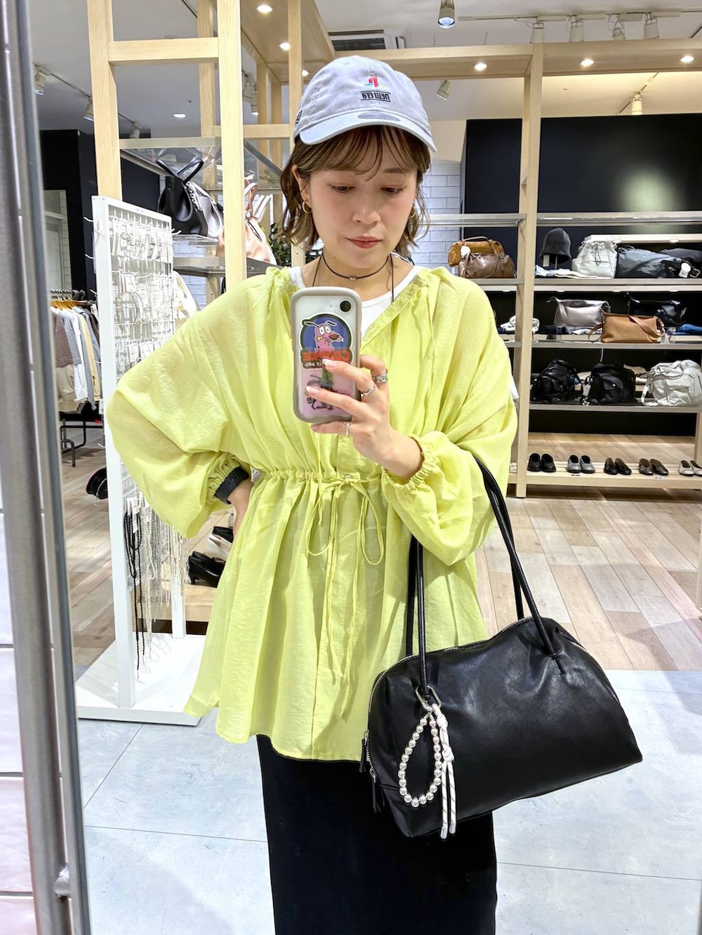 ブラック系のスカート、ブラック系のサンダル、ブラック系のボストンバッグを着用したレディースの春コーディネートの3枚目の写真