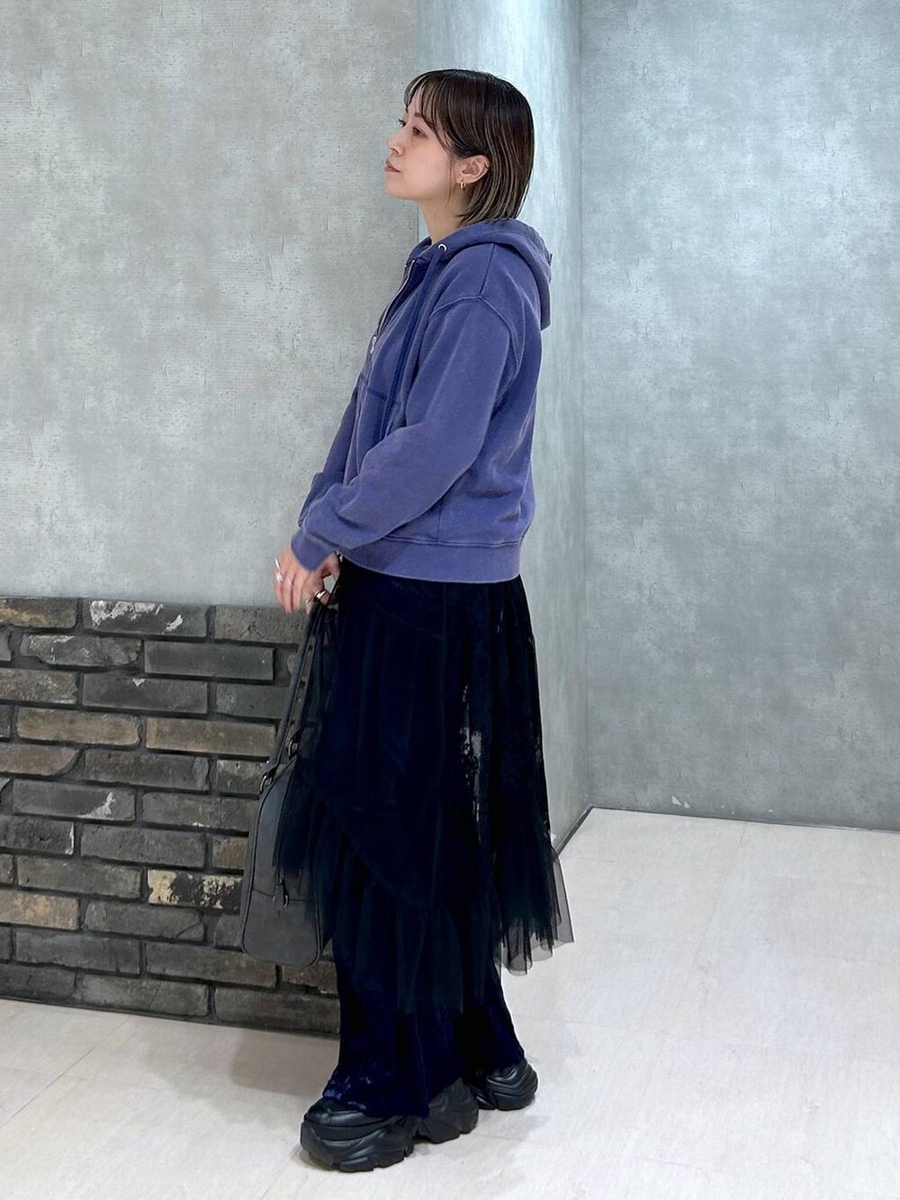 ブラック系のスニーカー、グレー系のボストンバッグ、ブラック系のキャミソールを着用したレディースの秋コーディネートの5枚目の写真