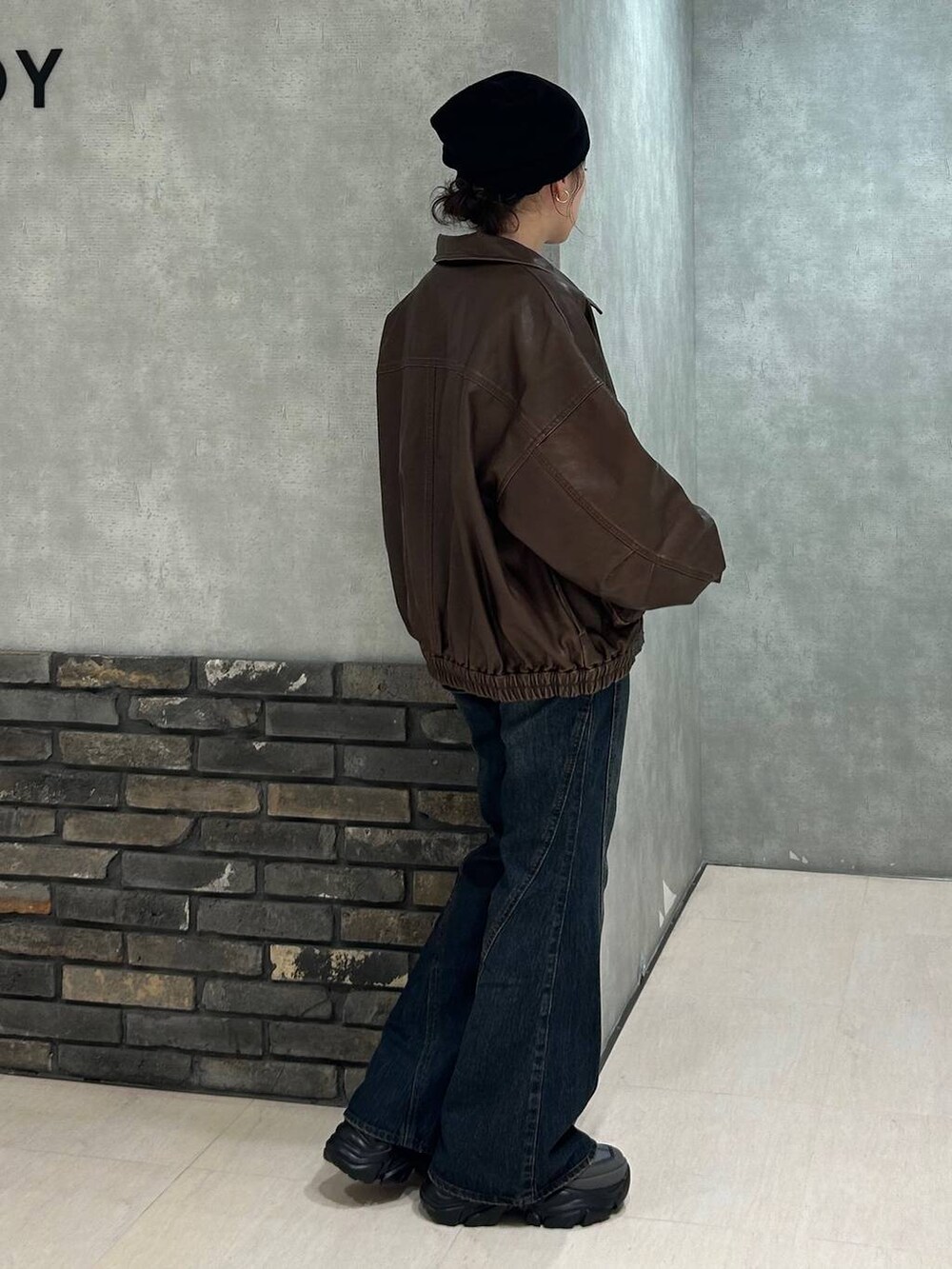 グレー系のスニーカー、ブルー系のデニムパンツ、ブラック系のTシャツ/カットソーを着用したレディースの秋コーディネートの3枚目の写真