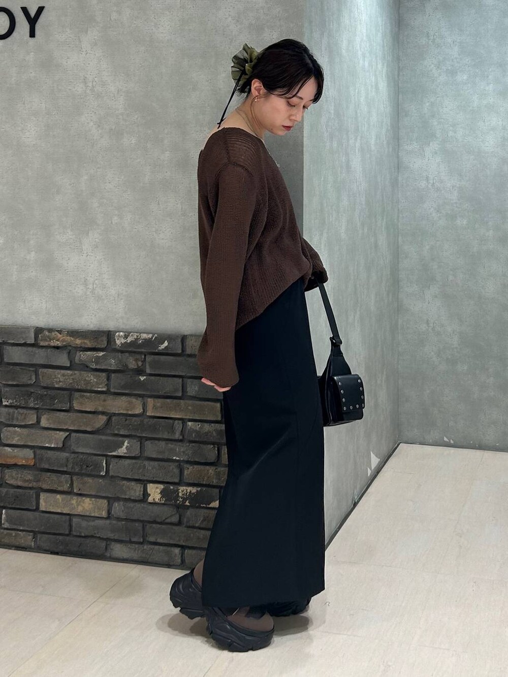 ブラウン系のブーツ、ブラック系のキャミソール、ブラウン系のニット/セーターを着用したレディースの秋コーディネートの4枚目の写真