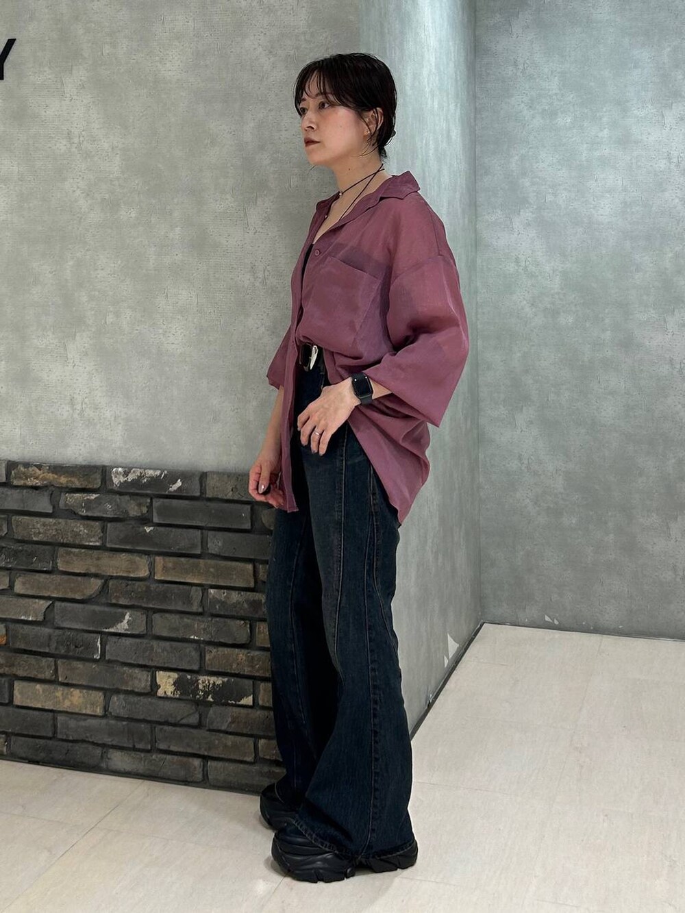 ブラック系のスニーカー、レッド系のシャツ/ブラウス、ブルー系のデニムパンツを着用したレディースの夏コーディネートの6枚目の写真