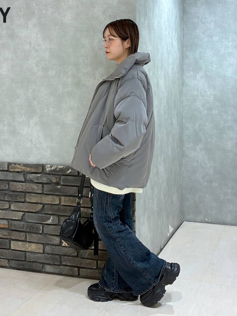 ブラック系のスニーカー、ブルー系のデニムパンツ、グレー系のブルゾンを着用したレディースの冬コーディネートの6枚目の写真