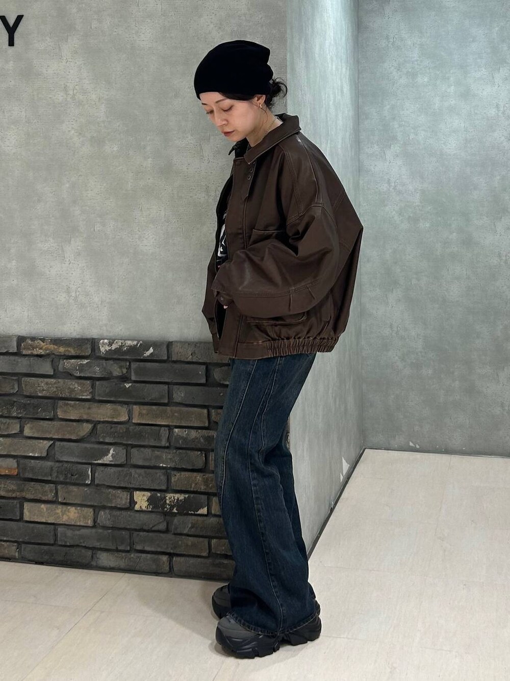 グレー系のスニーカー、ブルー系のデニムパンツ、ブラック系のTシャツ/カットソーを着用したレディースの秋コーディネートの5枚目の写真