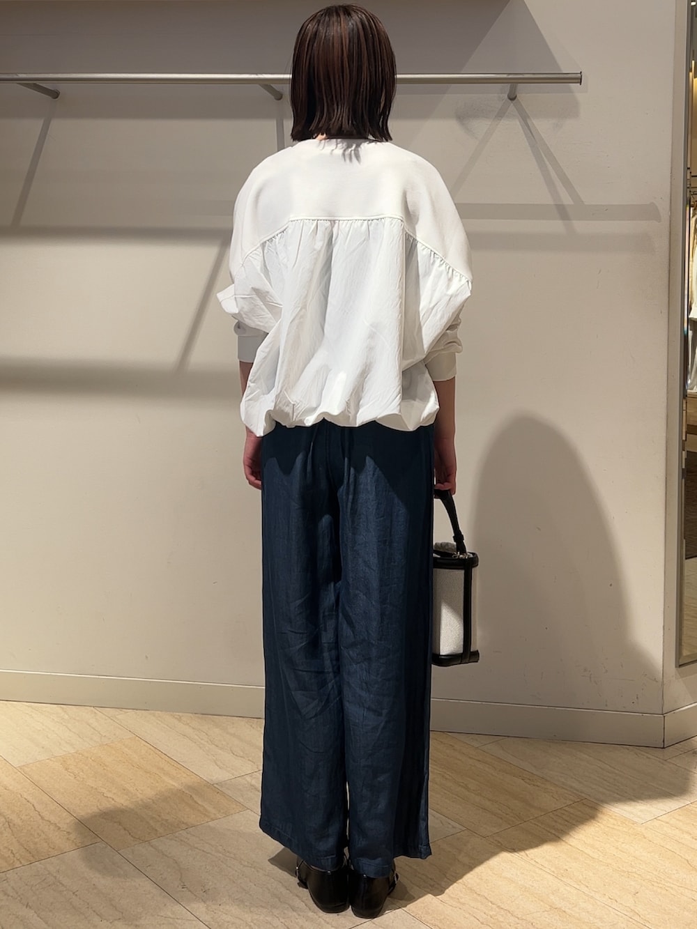 ホワイト系のTシャツ/カットソー、ブラック系のトートバッグ、ブルー系のその他パンツを着用したレディースの春コーディネートの2枚目の写真