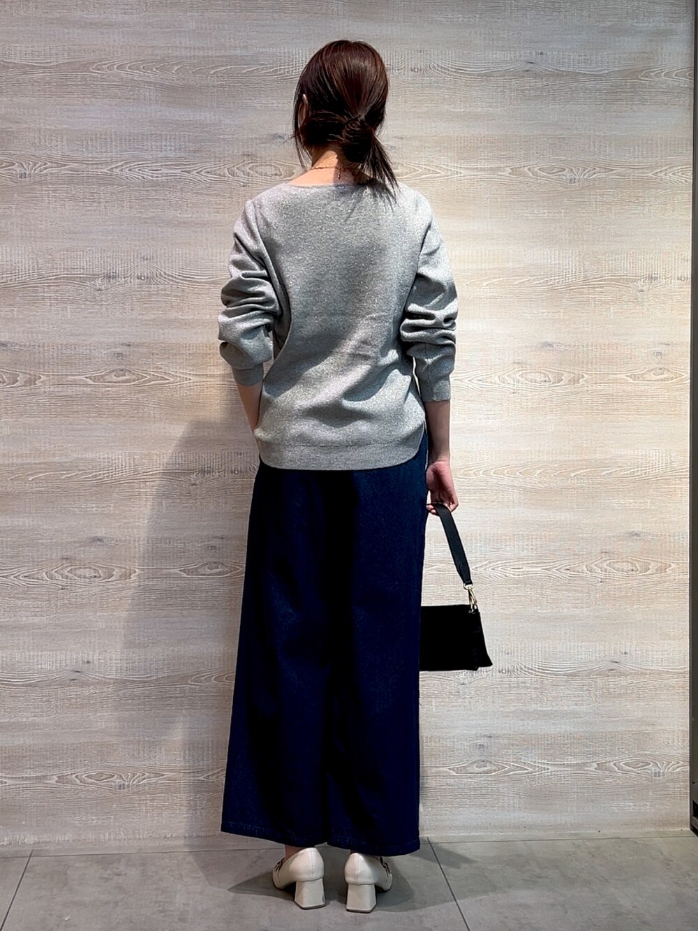 グレー系のニット/セーター、ブルー系のデニムパンツ、ブラック系のトートバッグを着用したレディースの冬コーディネートの2枚目の写真