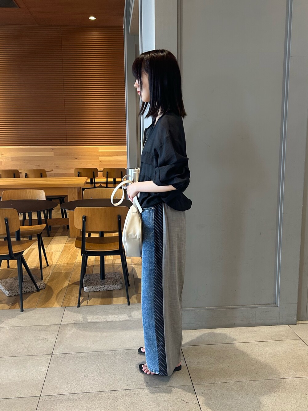 ブラック系のブルゾン、ブルー系のその他パンツ、グレー系のショルダーバッグを着用したレディースの夏コーディネートの3枚目の写真