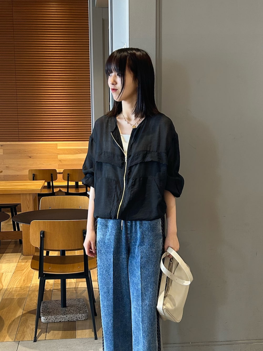 ブラック系のブルゾン、ブルー系のその他パンツ、グレー系のショルダーバッグを着用したレディースの夏コーディネートの2枚目の写真