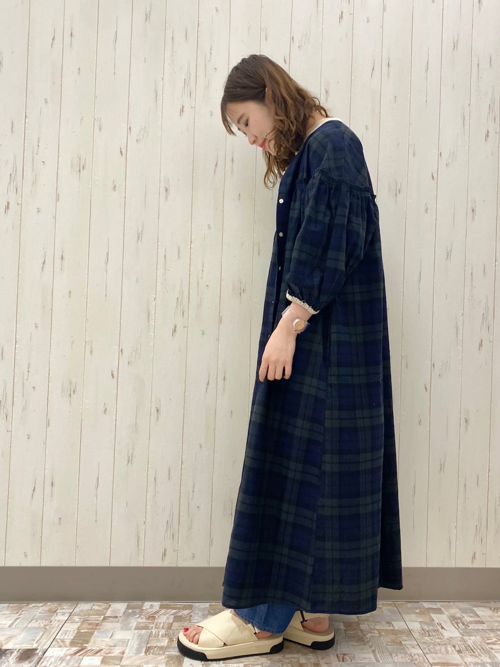 ブルー系のデニムパンツ、ホワイト系のサンダル、ベージュ系のTシャツ/カットソーを着用したレディースの夏コーディネートの2枚目の写真