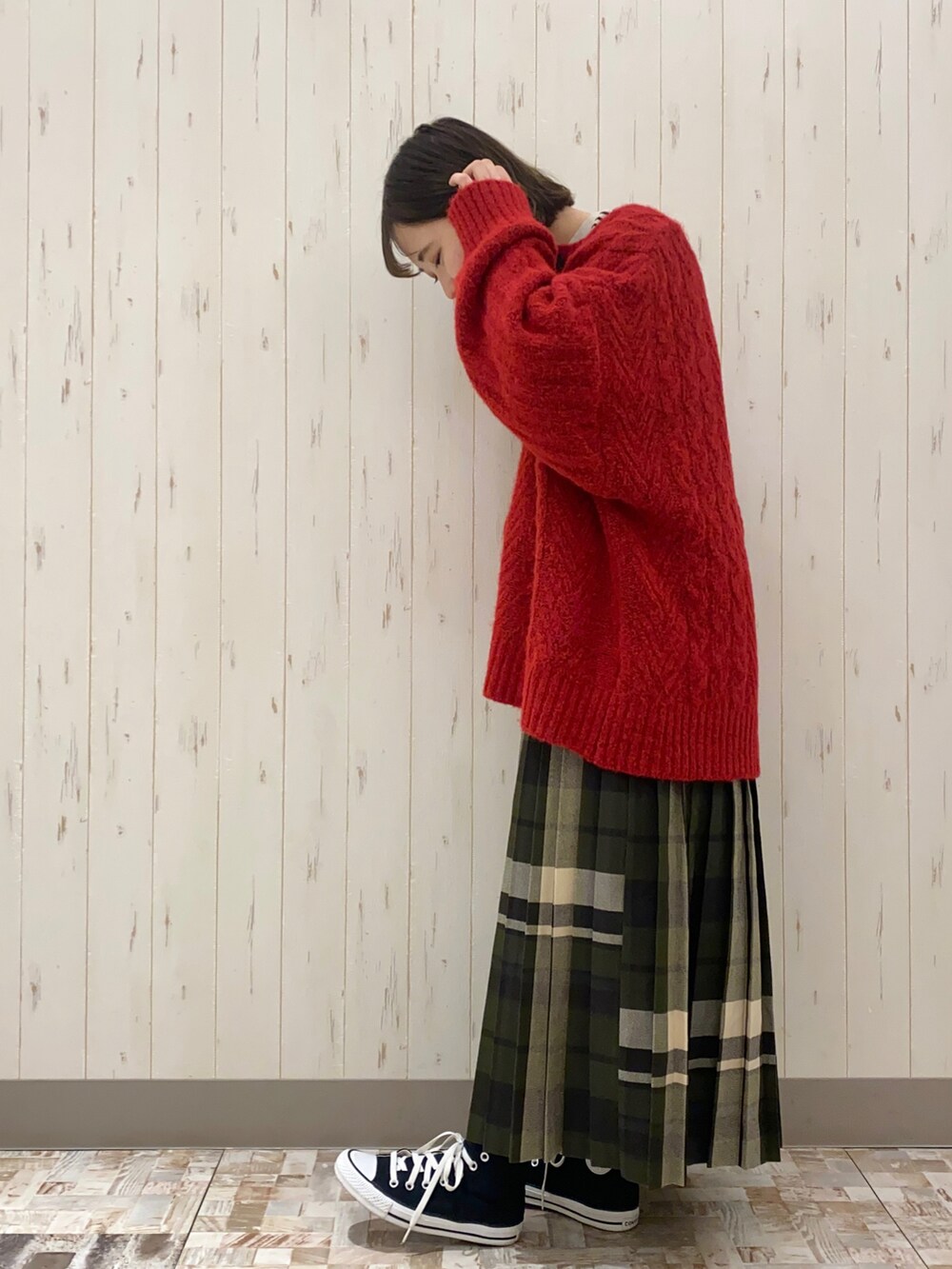 ベージュ系のハンドバッグ、レッド系のニット/セーター、ベージュ系のTシャツ/カットソーを着用したレディースの冬コーディネートの2枚目の写真