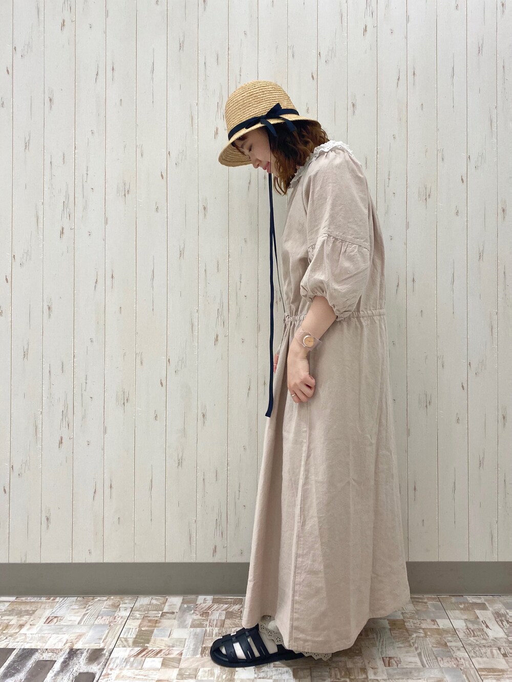 ベージュ系のワンピース、ホワイト系のトートバッグ、ブラック系のサンダルを着用したレディースの春コーディネートの3枚目の写真