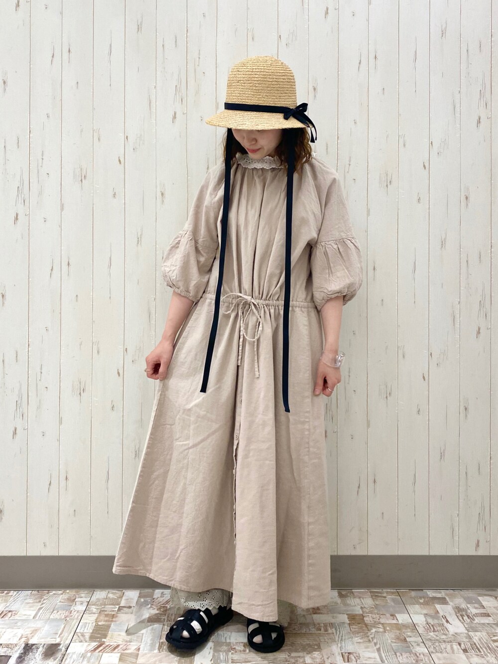 ベージュ系のワンピース、ホワイト系のトートバッグ、ブラック系のサンダルを着用したレディースの春コーディネートの2枚目の写真
