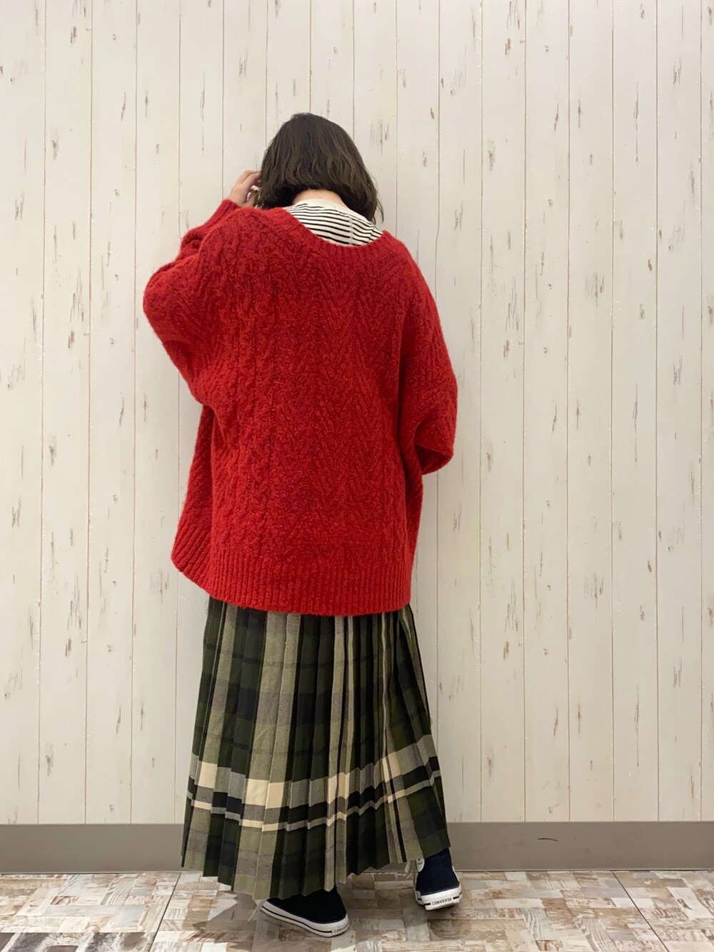 ベージュ系のハンドバッグ、レッド系のニット/セーター、ベージュ系のTシャツ/カットソーを着用したレディースの冬コーディネートの3枚目の写真