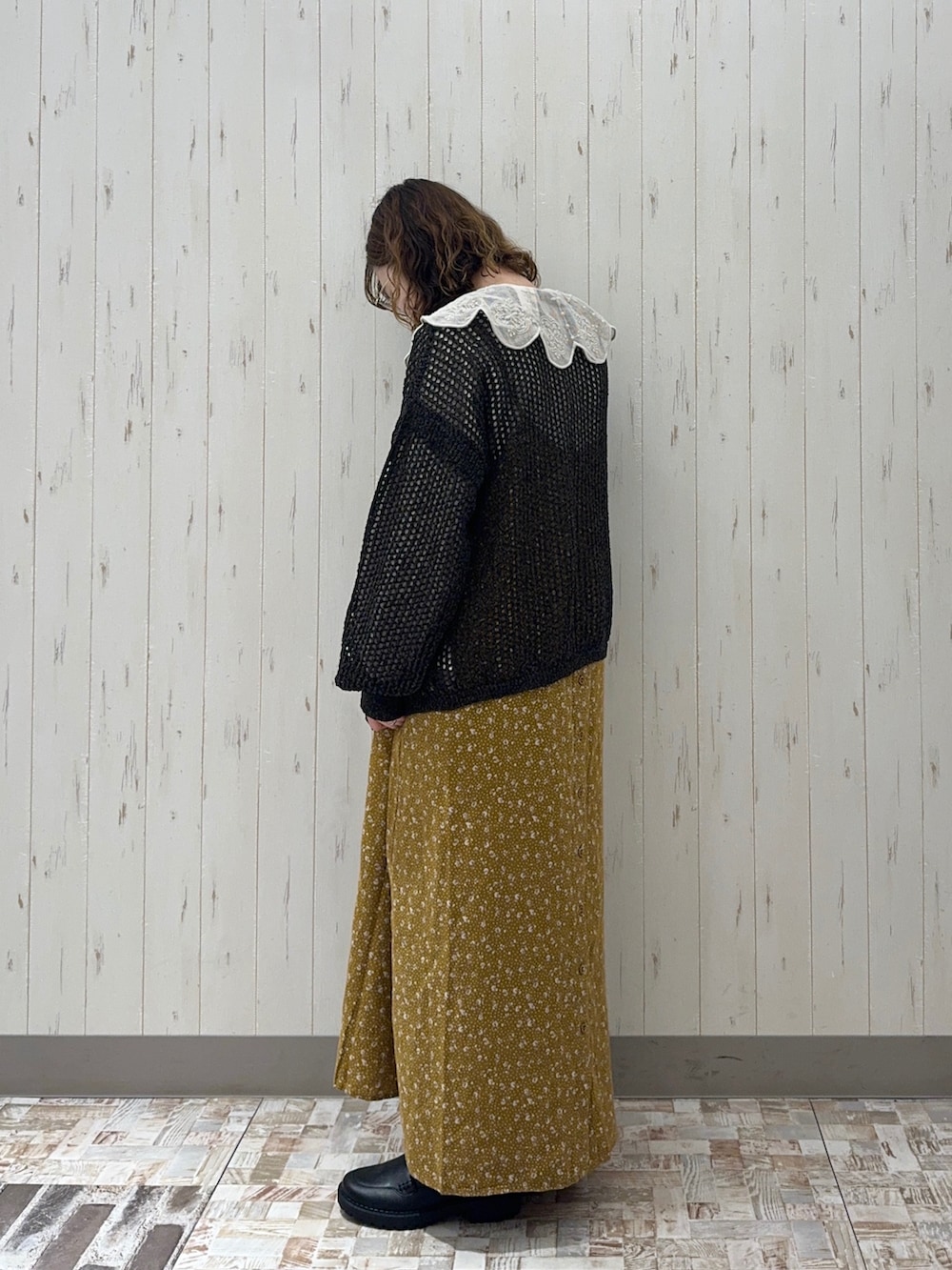 ブラック系のニット/セーター、ホワイト系のシャツ/ブラウス、イエロー系のワンピースを着用したレディースの秋コーディネートの2枚目の写真