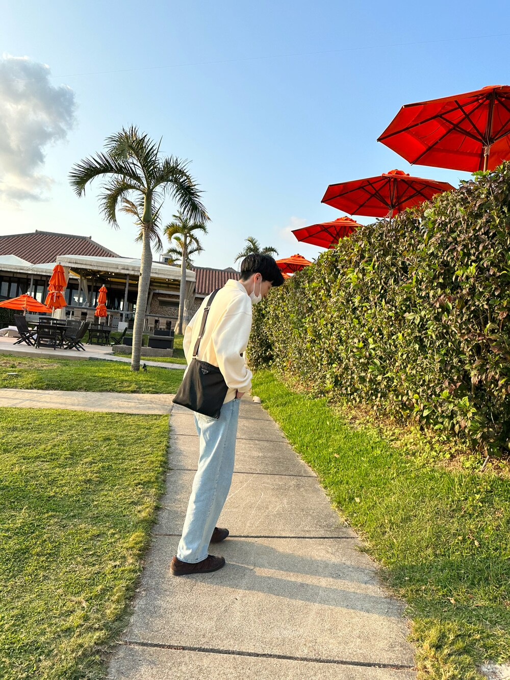 ブラウン系のスニーカー、ブルー系のデニムパンツ、ブラック系のショルダーバッグを着用したメンズの冬コーディネートの4枚目の写真