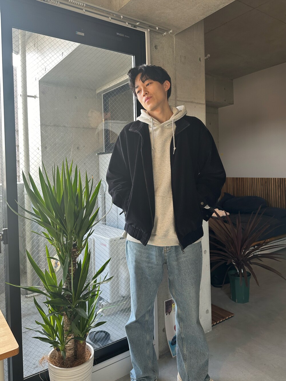 ブルー系のデニムパンツ、ベージュ系のスニーカーを着用したメンズの冬コーディネートの2枚目の写真