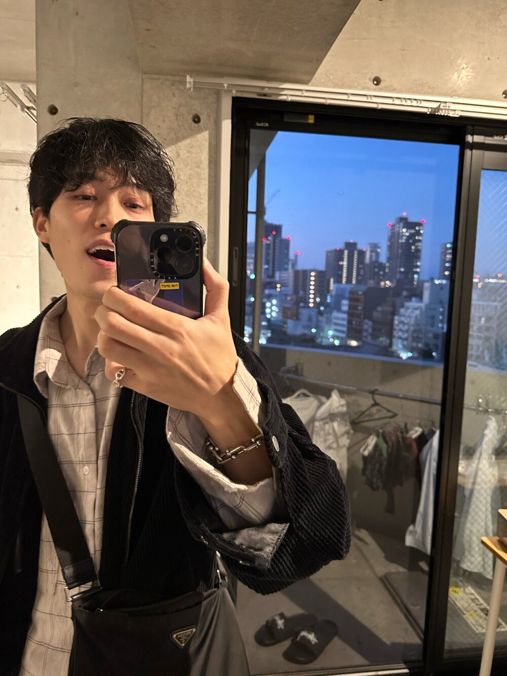 ブラック系のショルダーバッグ、ブルー系のデニムパンツを着用したメンズの秋コーディネートの2枚目の写真