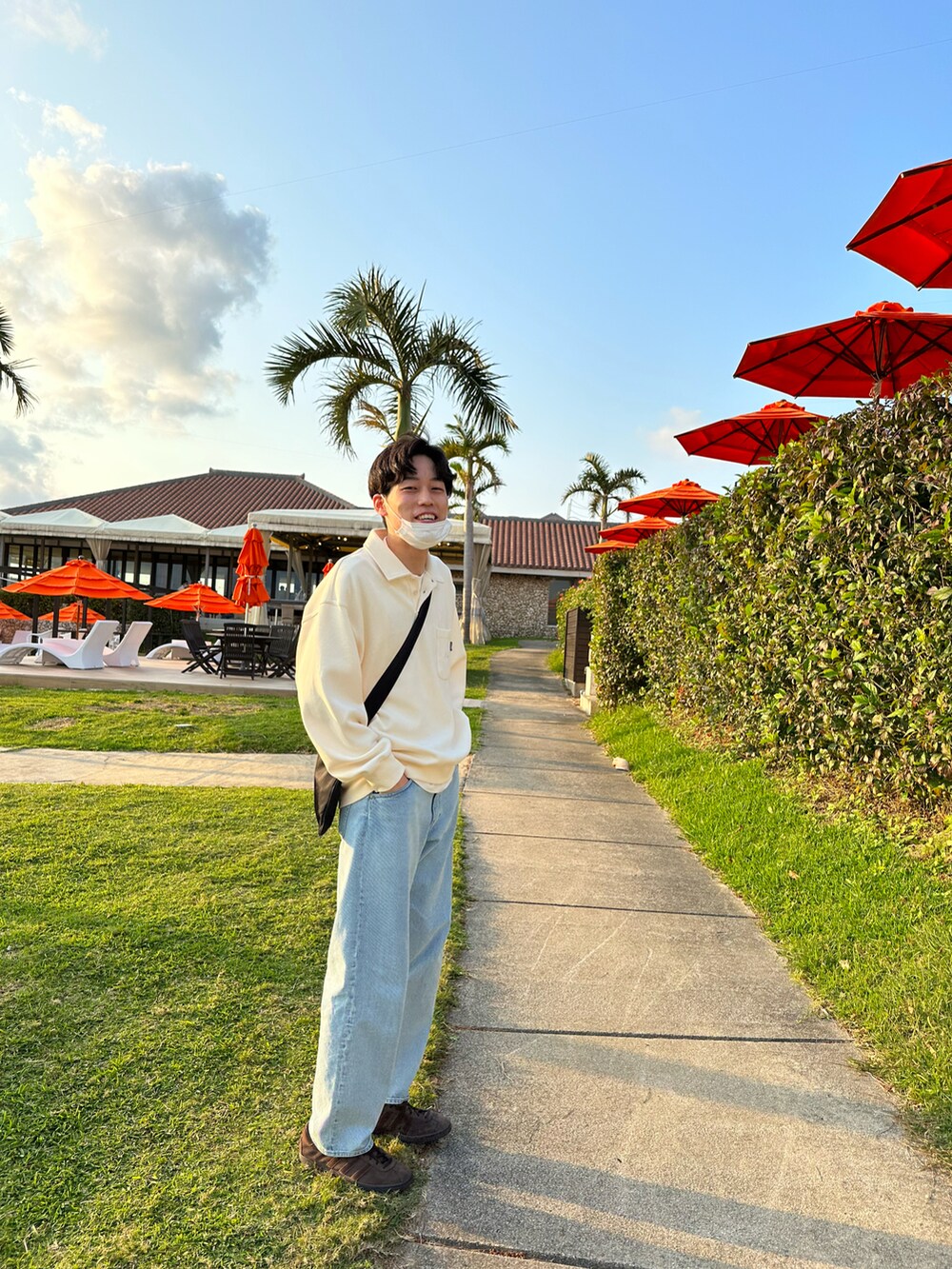 ブラウン系のスニーカー、ブルー系のデニムパンツ、ブラック系のショルダーバッグを着用したメンズの冬コーディネートの2枚目の写真