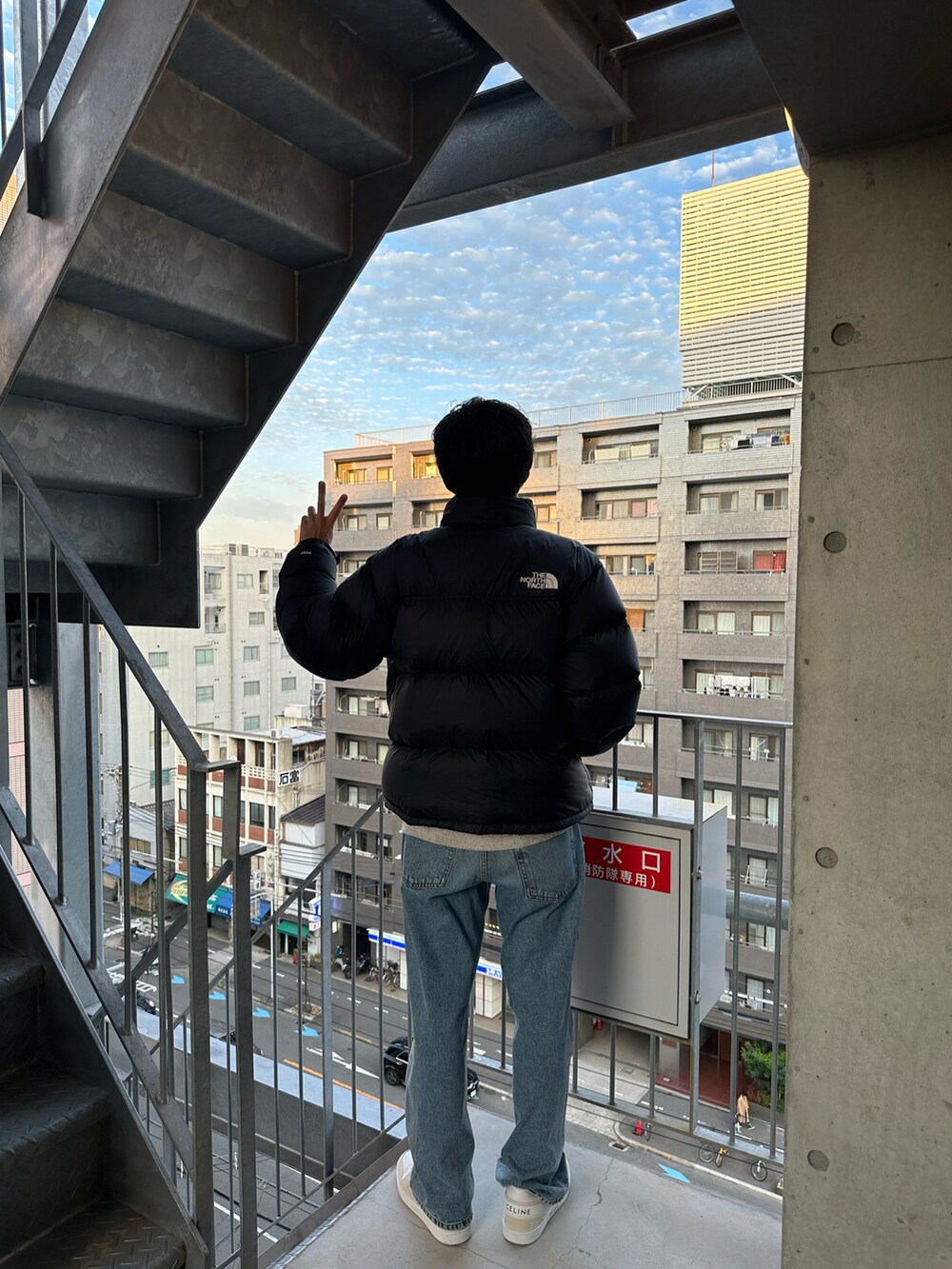 ブルー系のデニムパンツ、ベージュ系のスニーカー、ブラック系のダウンジャケット/コートを着用したメンズの秋コーディネートの4枚目の写真