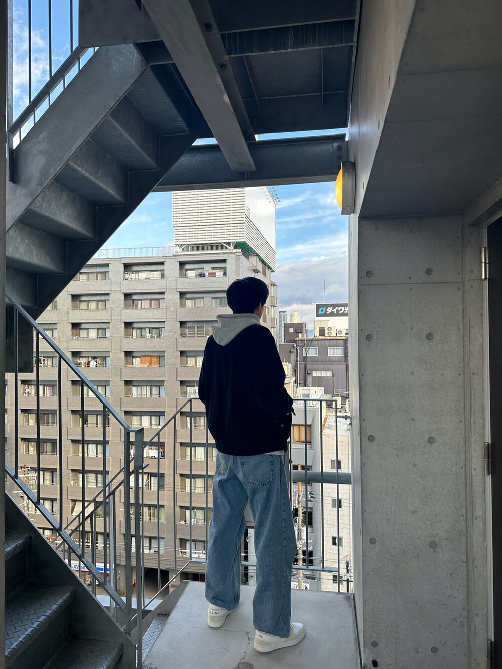 ブルー系のデニムパンツ、ベージュ系のスニーカーを着用したメンズの冬コーディネートの3枚目の写真