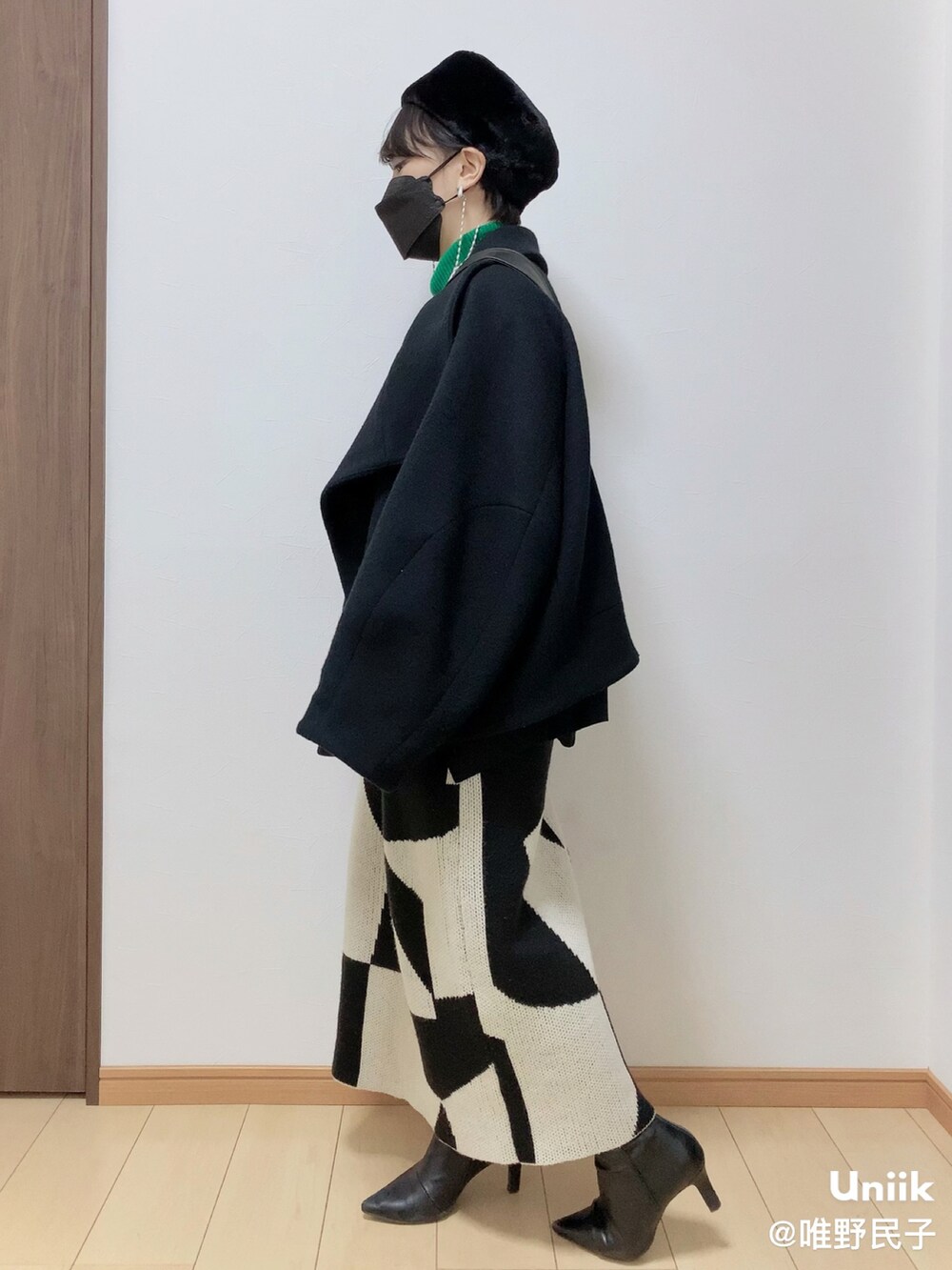 ブラック系のその他アウター、ホワイト系のスカート、ブラック系のブーツを着用したレディースの春コーディネートの3枚目の写真