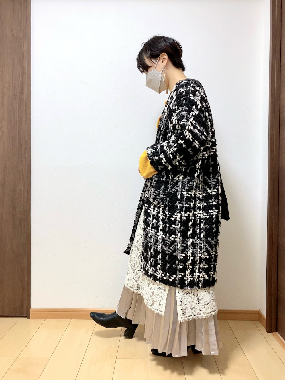ブラック系のその他アウター、ホワイト系のワンピース、ブラック系のボディバッグ/ウエストポーチを着用したレディースの冬コーディネートの2枚目の写真