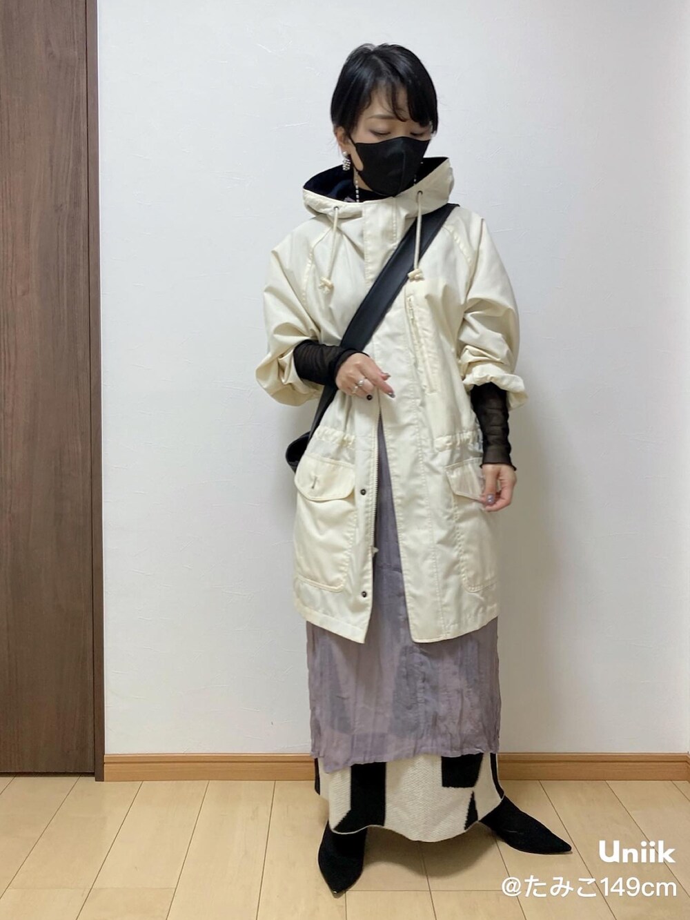 パープル系のワンピース、ホワイト系のスカート、ブラック系のパンプスを着用したレディースの春コーディネートの4枚目の写真