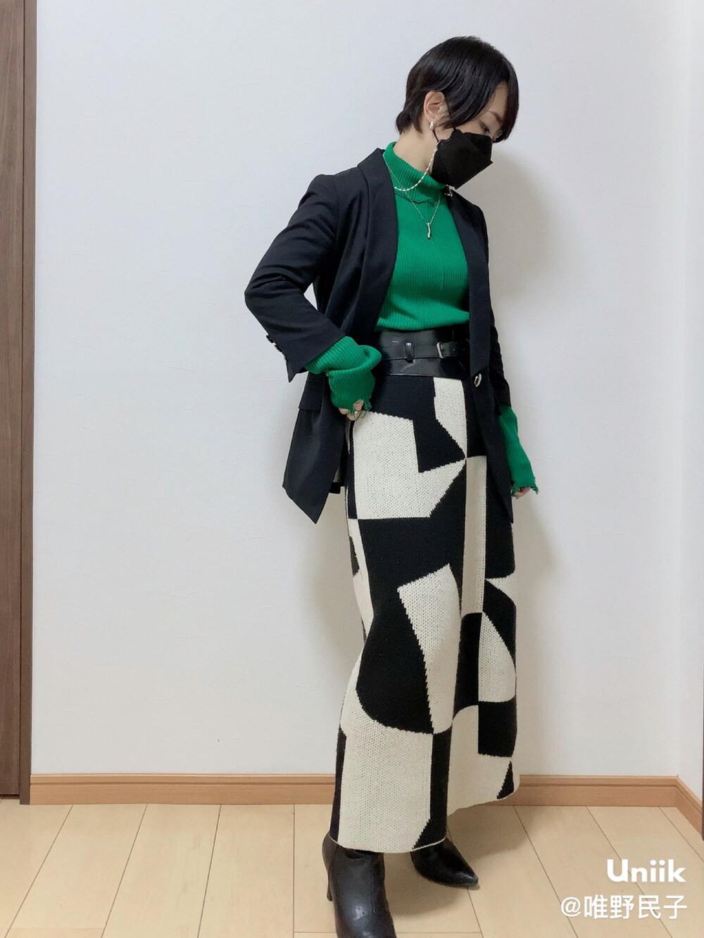 ブラック系のその他アウター、ホワイト系のスカート、ブラック系のブーツを着用したレディースの春コーディネートの2枚目の写真