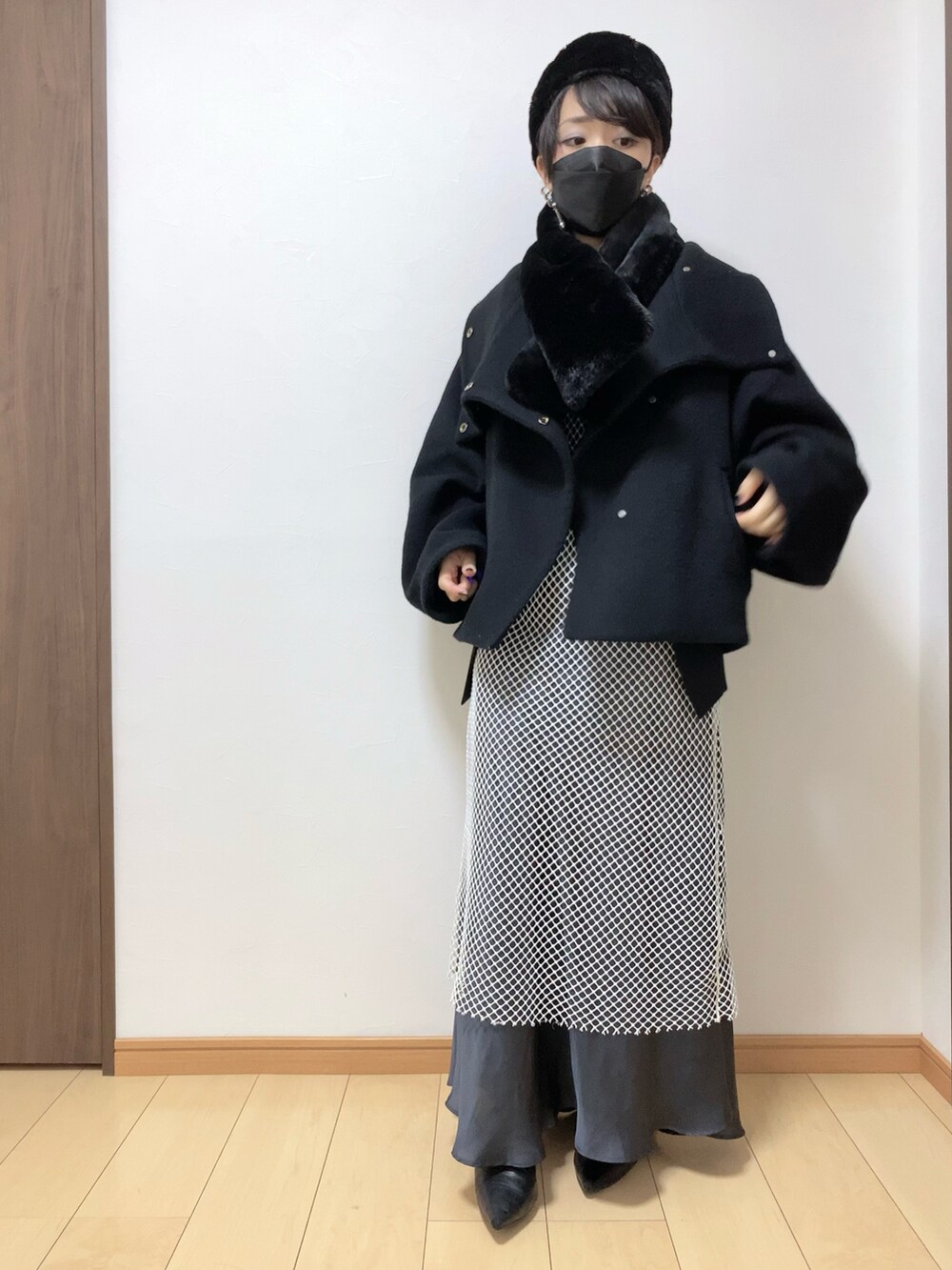 ブラック系のその他アウター、ホワイト系のワンピース/ドレス、グレー系のスカートを着用したレディースの冬コーディネートの2枚目の写真