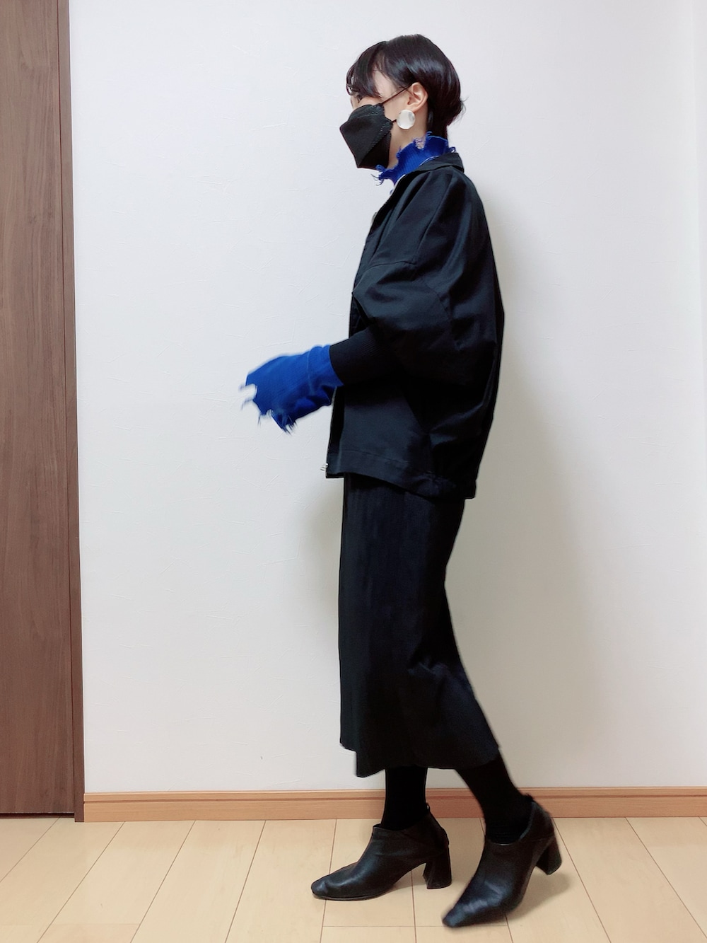 ブラック系のスカート、ブルー系のニット/セーター、ブラック系のその他アウターを着用したレディースの冬コーディネートの3枚目の写真