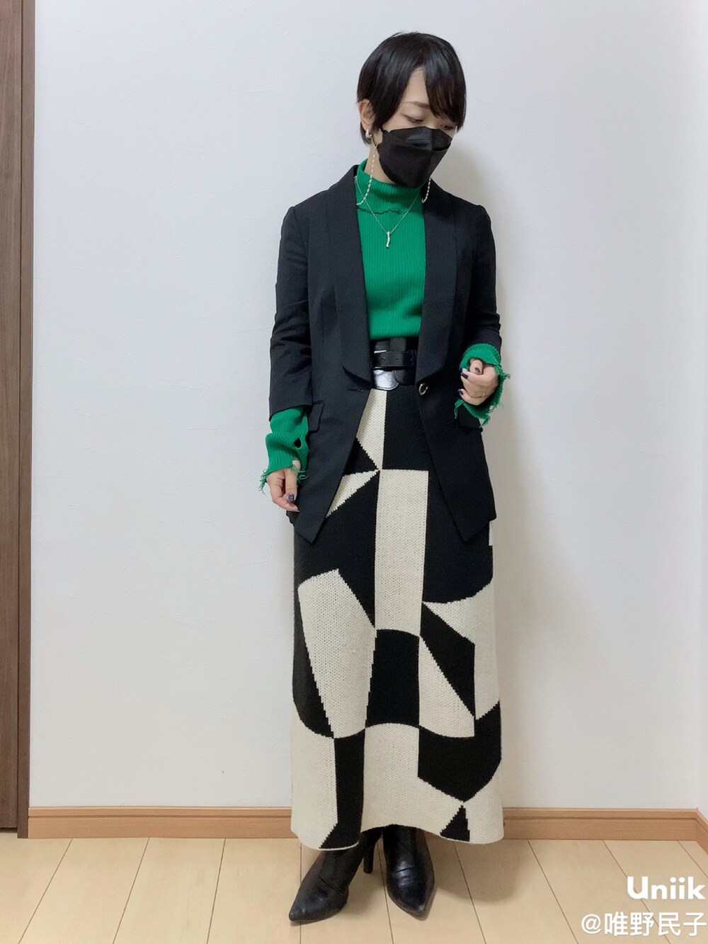 ブラック系のその他アウター、ホワイト系のスカート、ブラック系のブーツを着用したレディースの春コーディネートの4枚目の写真