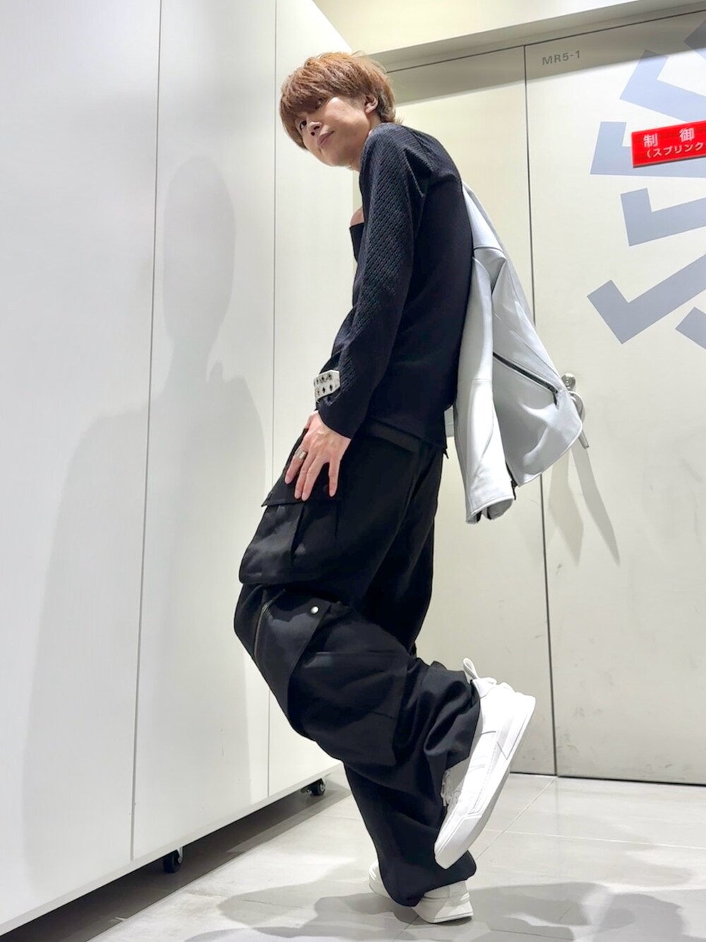 ホワイト系のスニーカー、ブラック系のTシャツ/カットソー、ホワイト系のライダースジャケットを着用したメンズの秋コーディネートの3枚目の写真