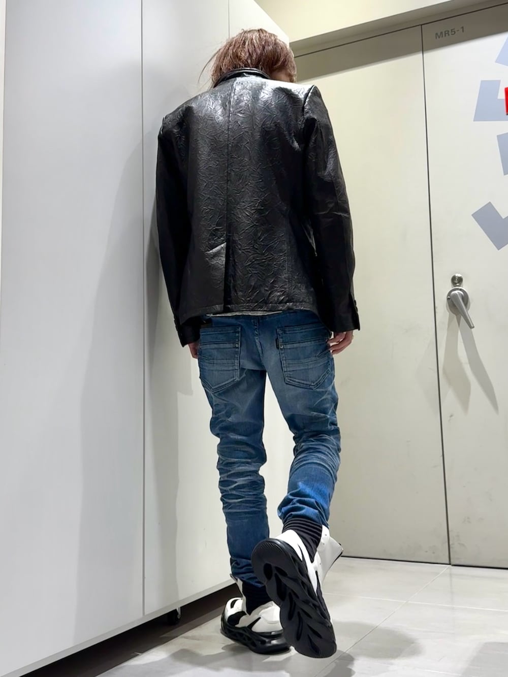 ブルー系のデニムパンツ、ホワイト系のその他シューズ、ブラック系のその他アウターを着用したメンズの冬コーディネートの3枚目の写真