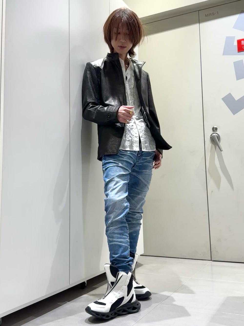 ブルー系のデニムパンツ、ホワイト系のその他シューズ、ブラック系のその他アウターを着用したメンズの冬コーディネートの2枚目の写真