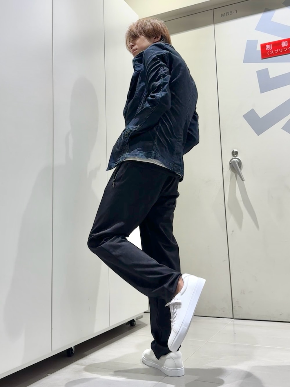 グレー系のTシャツ/カットソー、ブルー系のデニムジャケット、ブラック系のスウェットパンツを着用したメンズの秋コーディネートの3枚目の写真