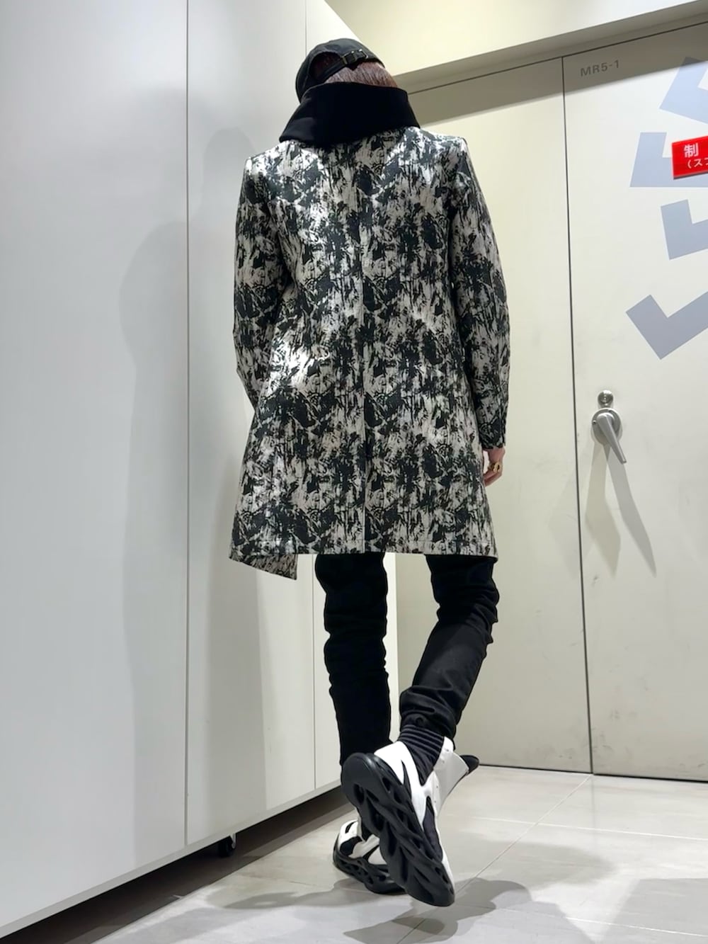 ブラック系のTシャツ/カットソー、ホワイト系のトレンチコート、ホワイト系のその他シューズを着用したメンズの冬コーディネートの3枚目の写真