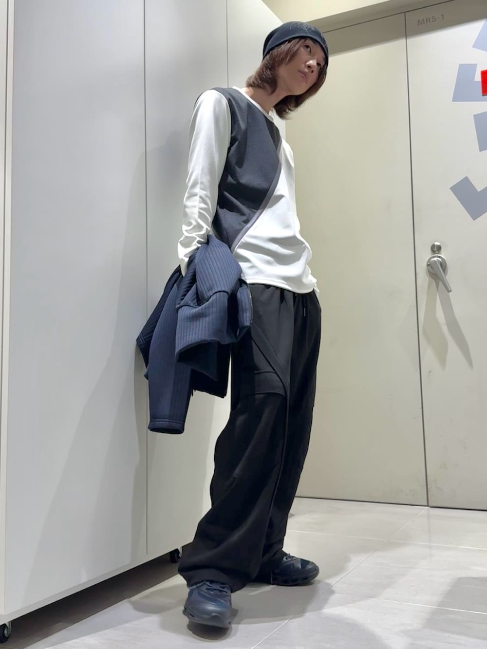 ブラック系のパンツ、ブルー系のスニーカー、ブルー系のカーディガン/ボレロを着用したメンズの冬コーディネートの3枚目の写真