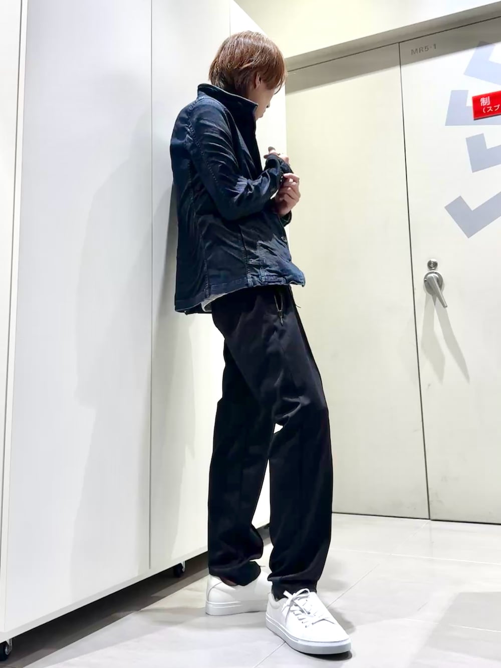 グレー系のTシャツ/カットソー、ブルー系のデニムジャケット、ブラック系のスウェットパンツを着用したメンズの秋コーディネートの2枚目の写真