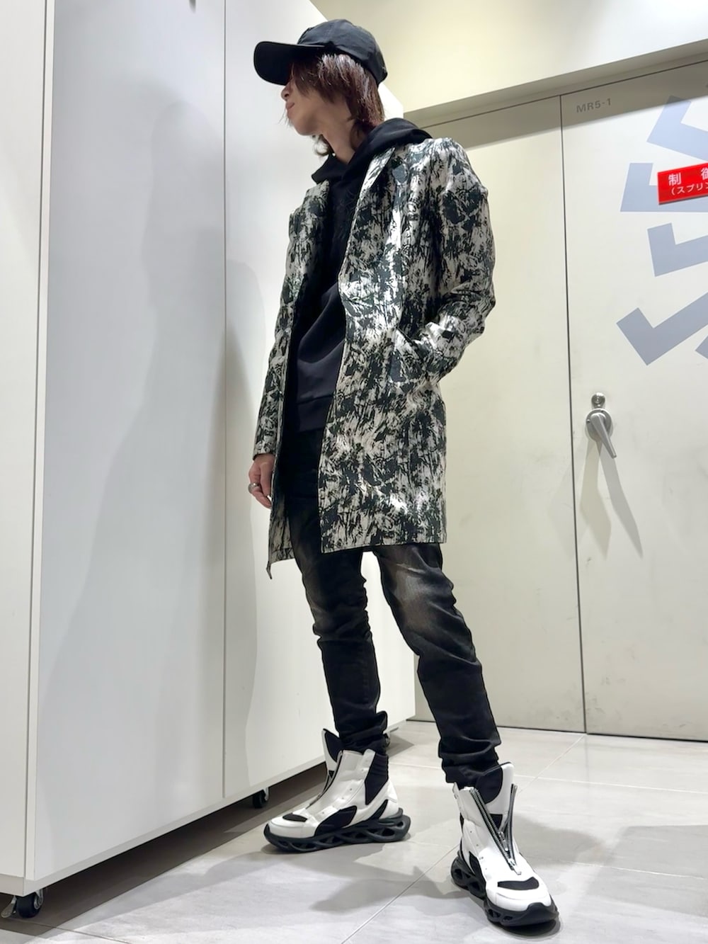 ブラック系のTシャツ/カットソー、ホワイト系のトレンチコート、ホワイト系のその他シューズを着用したメンズの冬コーディネートの2枚目の写真