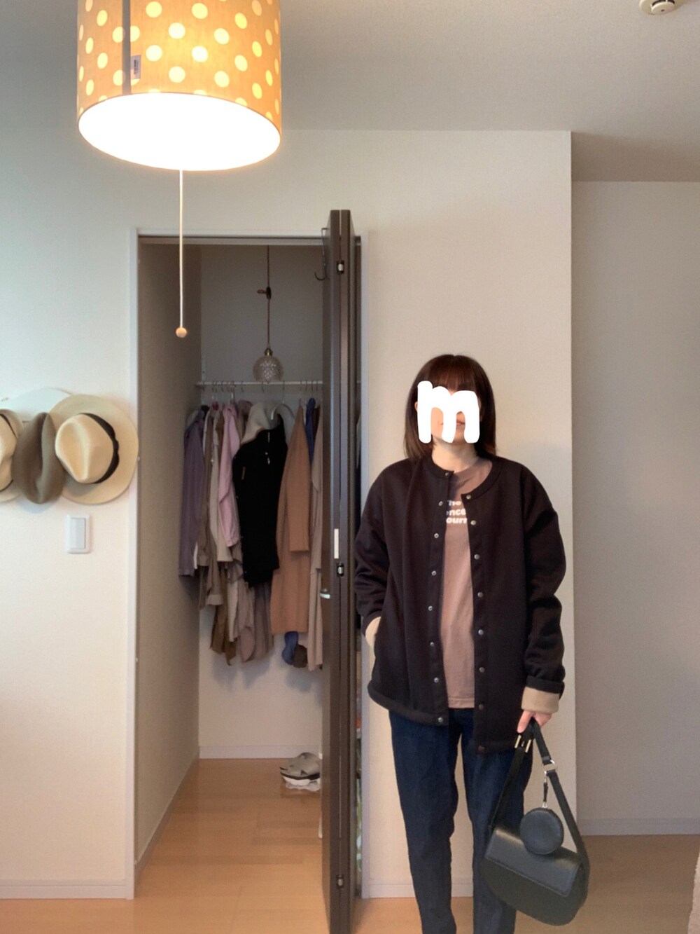 ブラック系のカーディガン/ボレロ、ブルー系のデニムパンツ、ブラック系のショルダーバッグを着用したレディースの秋コーディネートの2枚目の写真