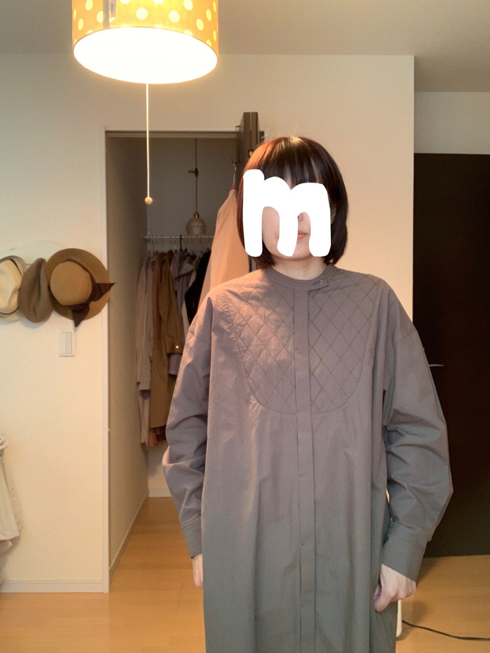 グリーン系のワンピース、ブルー系のデニムパンツを着用したレディースの春コーディネートの2枚目の写真