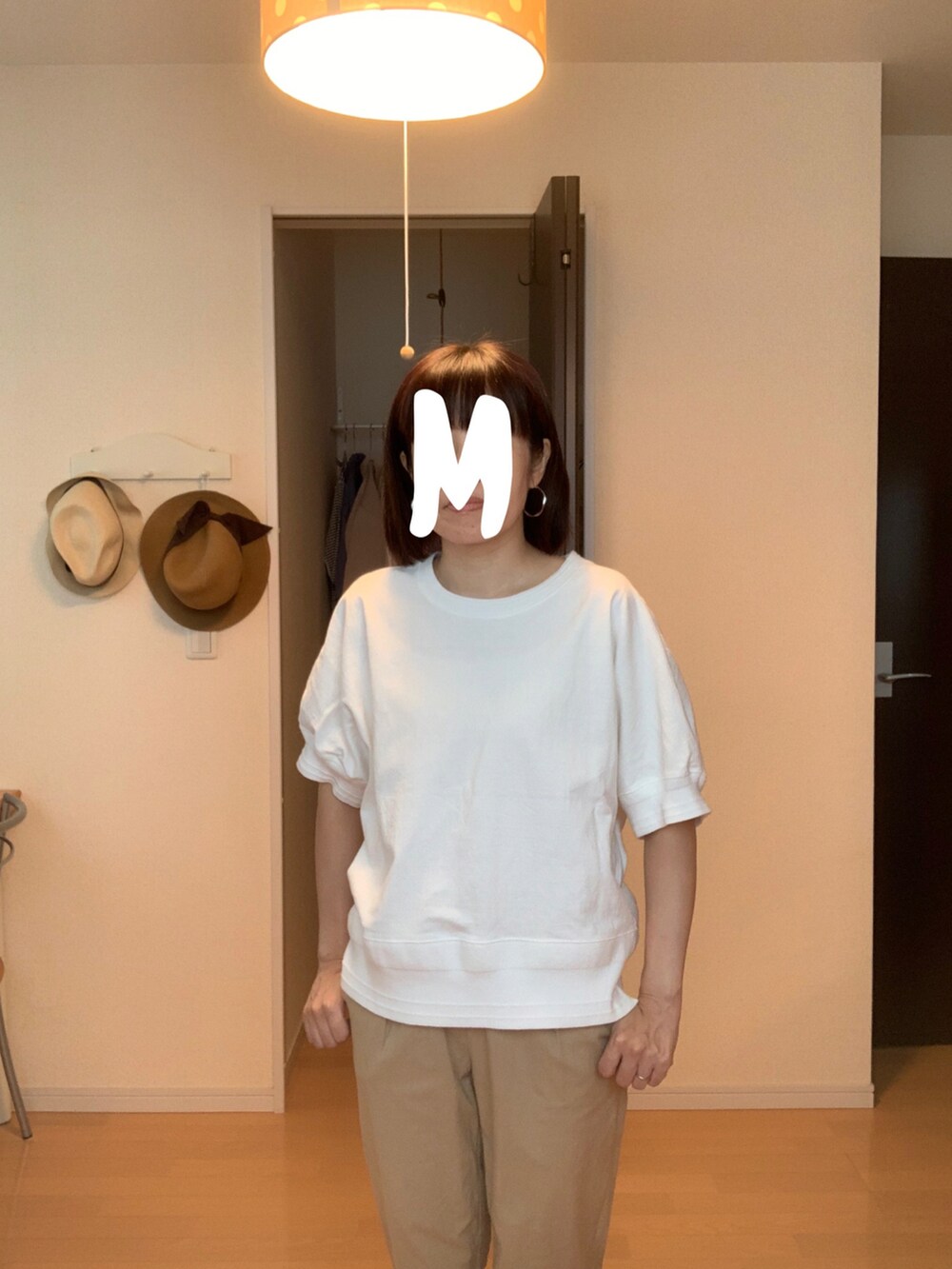 ベージュ系のパンツ、ホワイト系のTシャツ/カットソーを着用したレディースの秋コーディネートの2枚目の写真