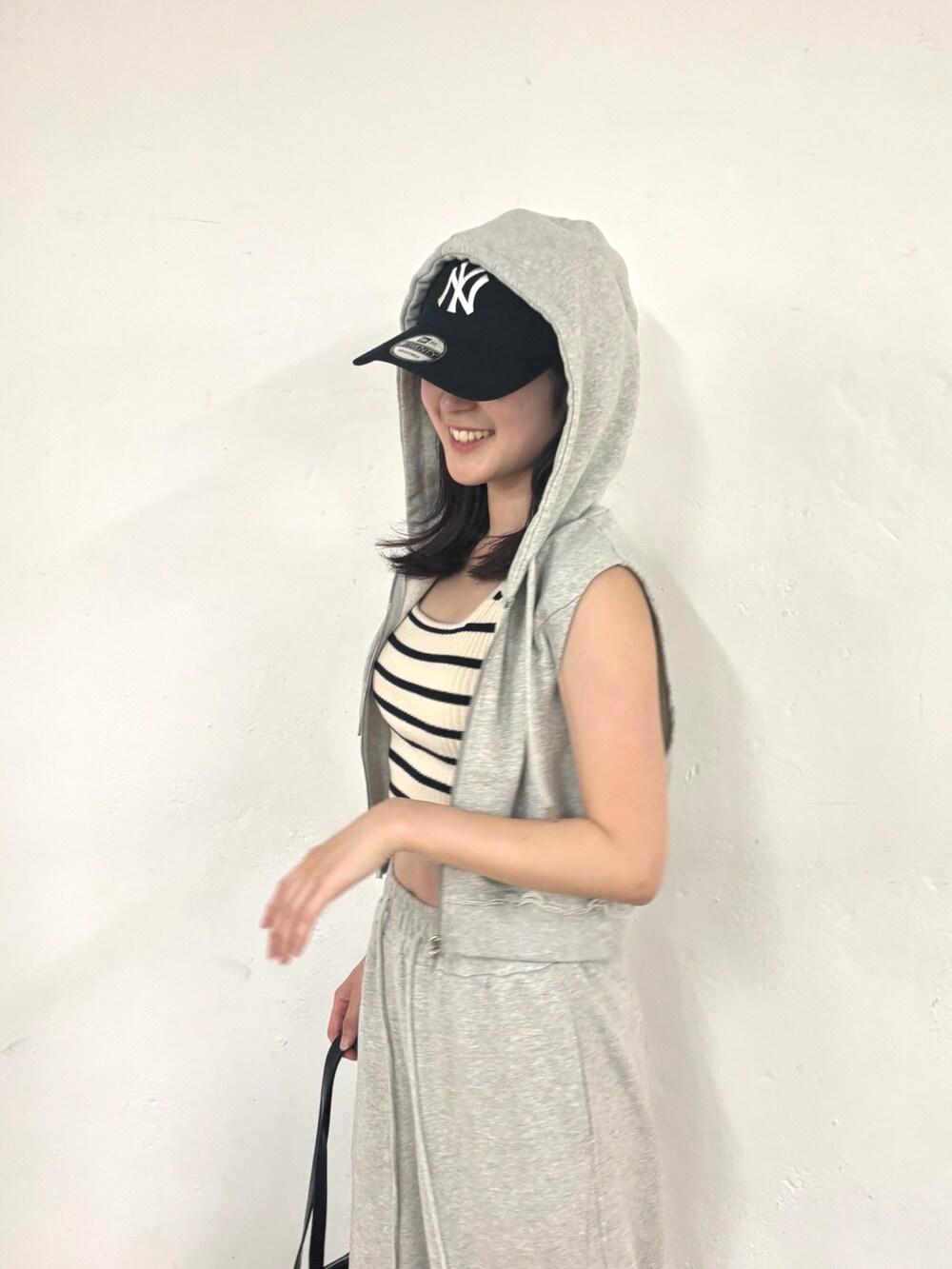 グレー系のスウェットパンツ、グレー系のTシャツ/カットソー、ホワイト系のタンクトップを着用したレディースの夏コーディネートの4枚目の写真