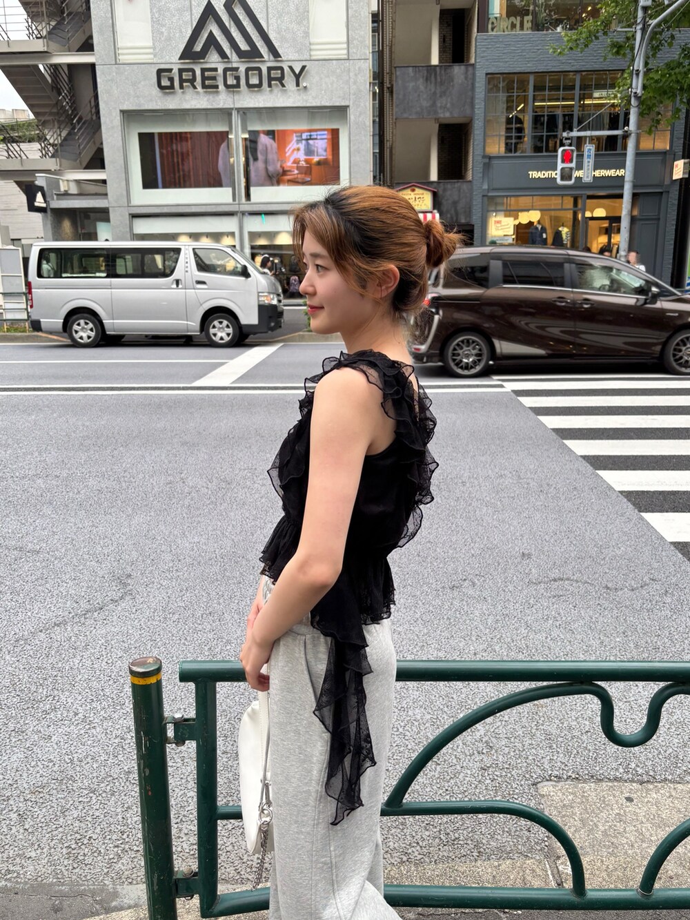 ブラック系のシャツ/ブラウス、グレー系のスウェットパンツ、ホワイト系のショルダーバッグを着用したレディースの春コーディネートの4枚目の写真