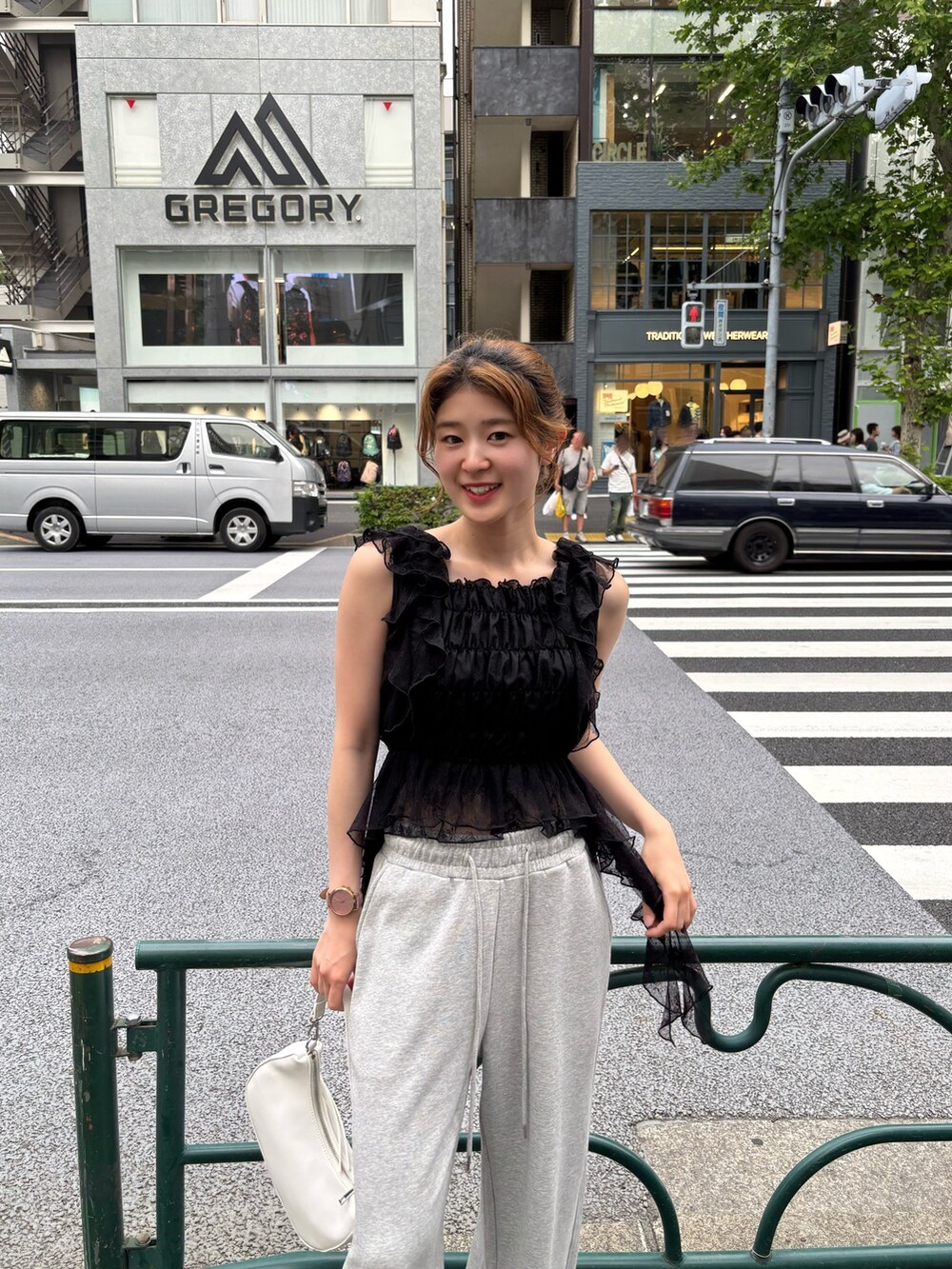 ブラック系のシャツ/ブラウス、グレー系のスウェットパンツ、ホワイト系のショルダーバッグを着用したレディースの春コーディネートの3枚目の写真