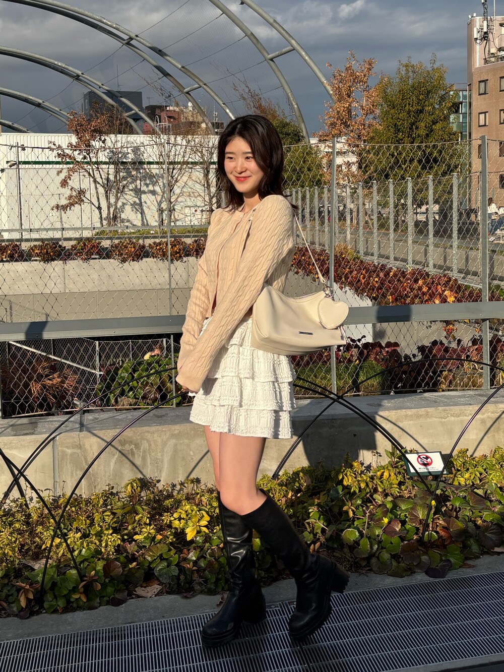 イエロー系のその他アウター、ホワイト系のその他パンツ、ホワイト系のショルダーバッグを着用したレディースの春コーディネートの2枚目の写真