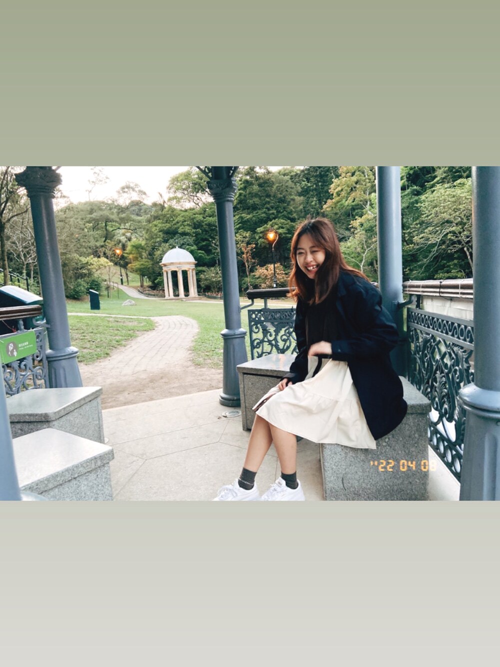 ホワイト系のスニーカー、ブラウン系のワンピース、ブラック系のシャツ/ブラウスを着用したレディースの春コーディネートの2枚目の写真