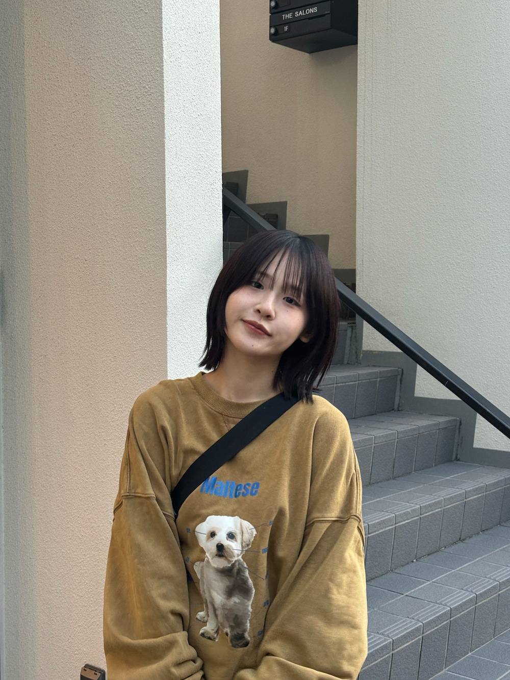 ブラウン系のパンツ、ブラック系のスニーカー、ブラック系のブルゾンを着用したレディースの冬コーディネートの3枚目の写真