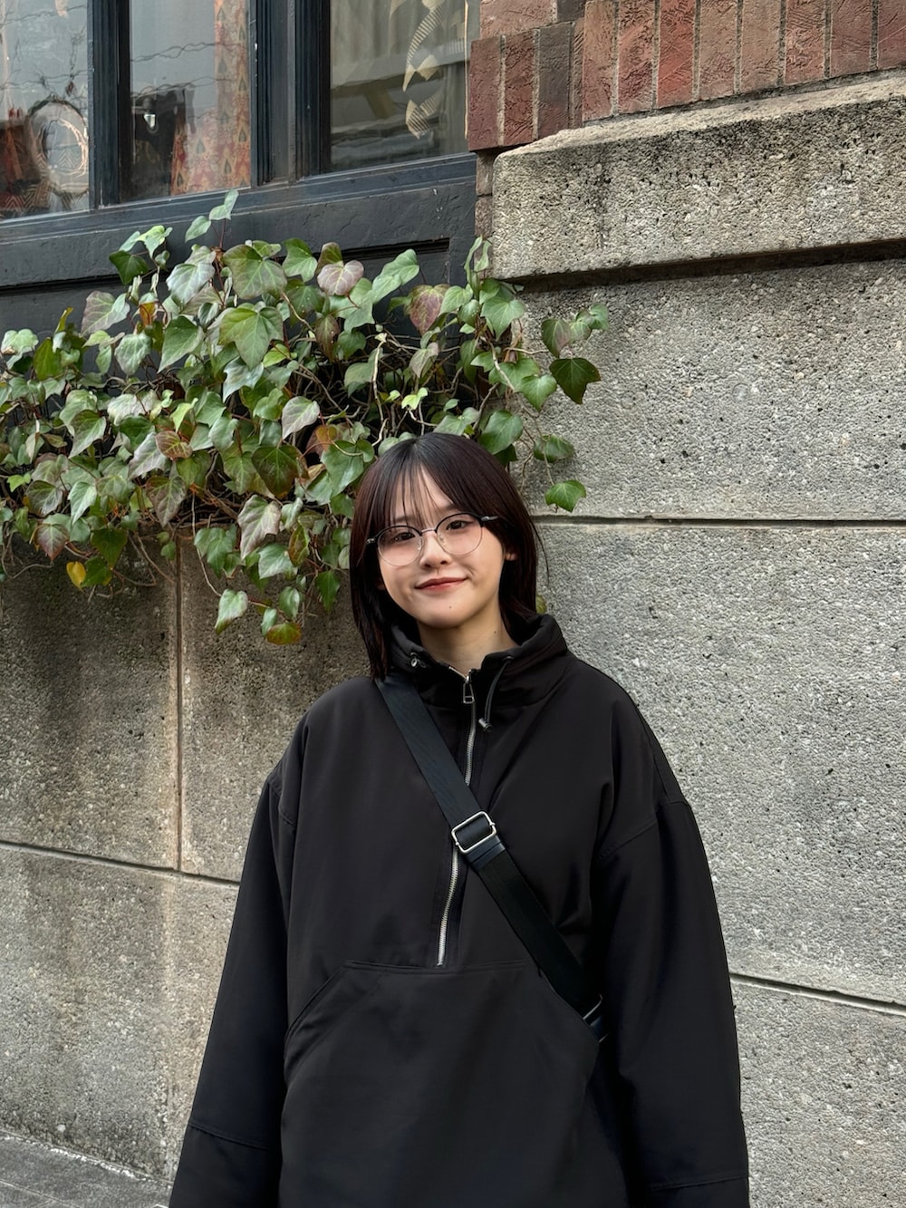 ブラウン系のパンツ、ブラック系のスニーカー、ブラック系のブルゾンを着用したレディースの冬コーディネートの2枚目の写真